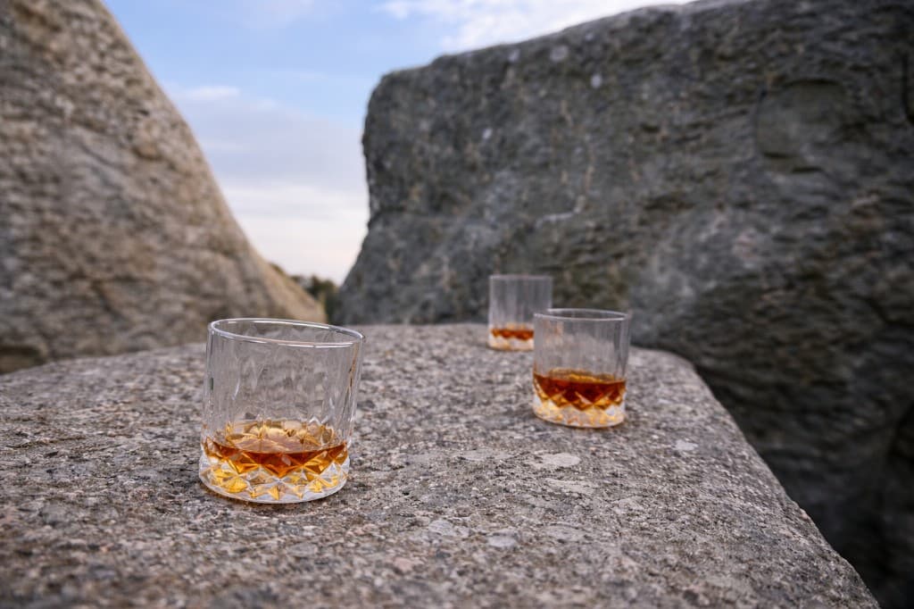 Whisky glasses with a Speyside distillery in the background